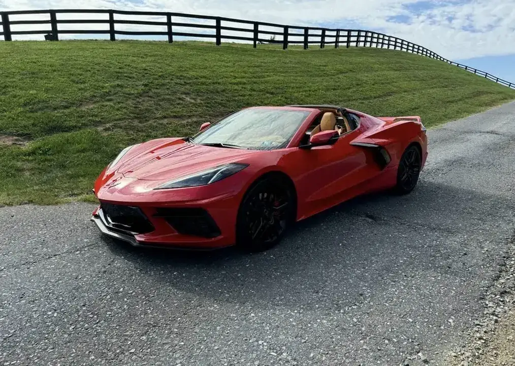 A client's new red Chevrolet Corvette parked on a country road