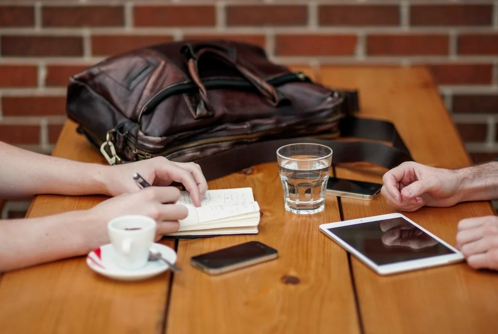 Two people going through the numbers at a table