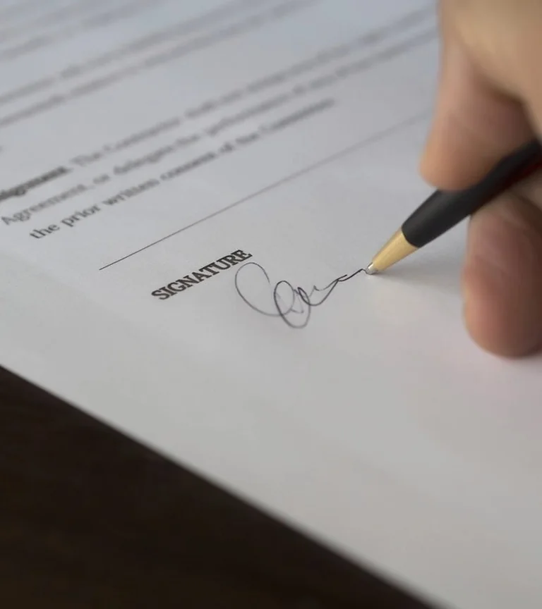 A contract being signed at the end of a negotiation