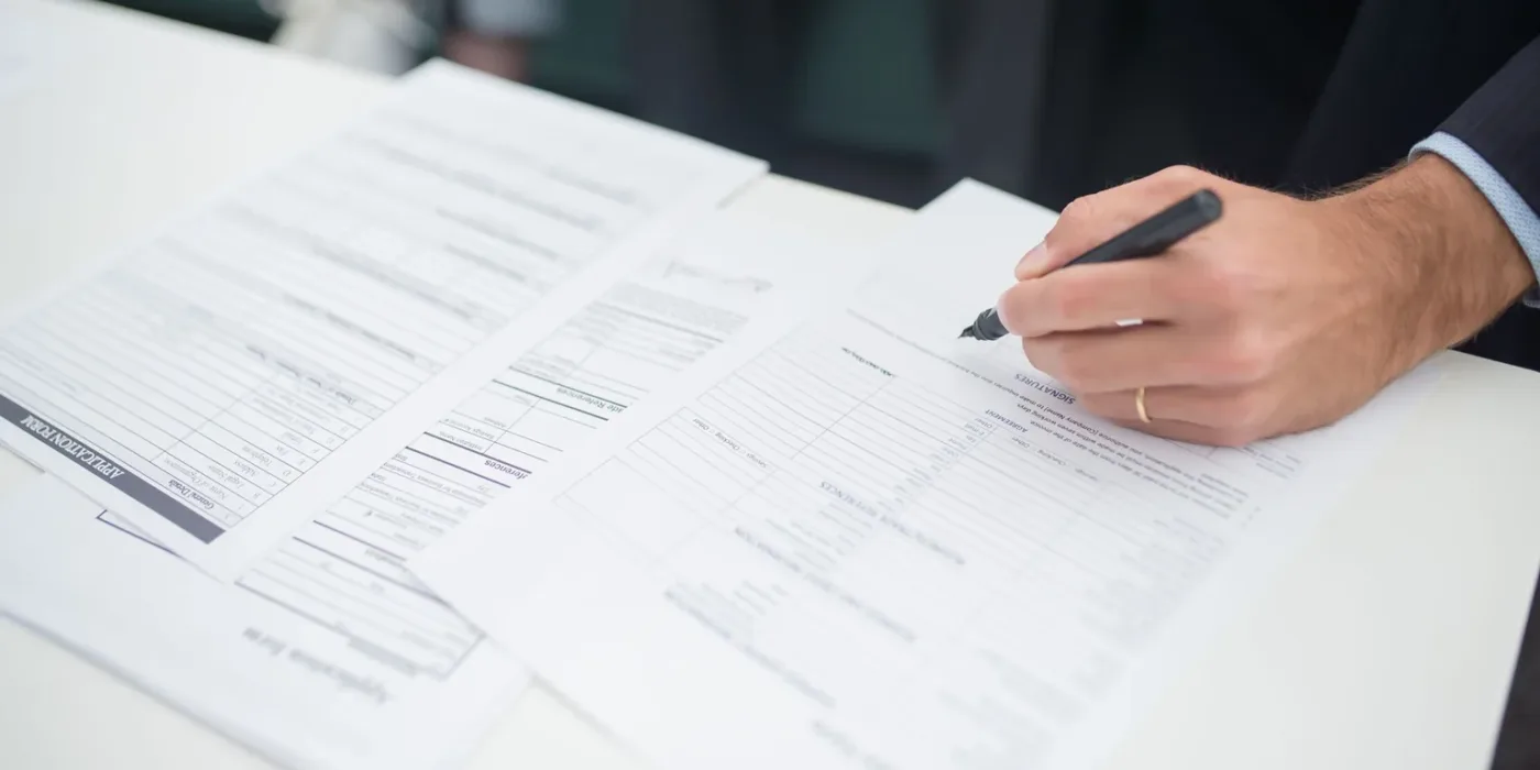 A buyer reading the fine print and signing the purchase paperwork