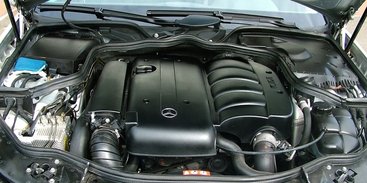 A silver car with the hood open, showing the engine bay